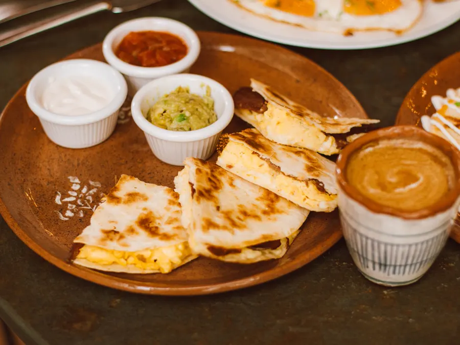 Quesadilla with salsas on a wooden board