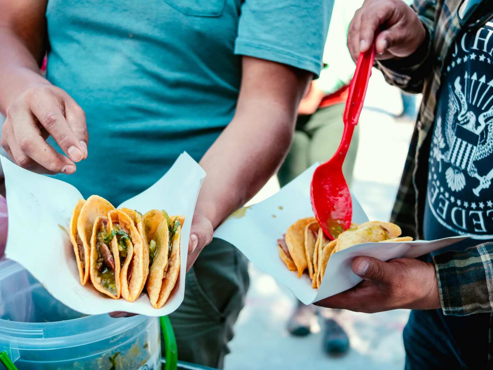 Hands holding street tacos